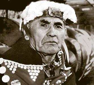 A photo of a chief in cedar and fur headdress