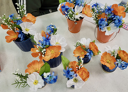 Flower arrangements in the Edmonton Oilers colours of blue, orange and white.