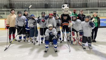 Young hockey players gather on the ice for a group photo.