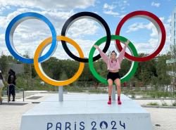 A woman poses with the Olympic rings at the Paris Olympics.